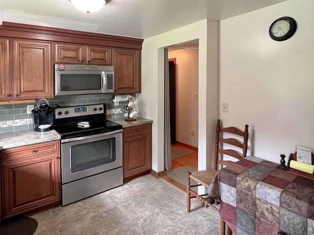 74 E Ridge Rd, Warwick, NY 10990 - kitchen with appliances with stainless steel finishes, decorative backsplash, brown cabinets, and baseboards
