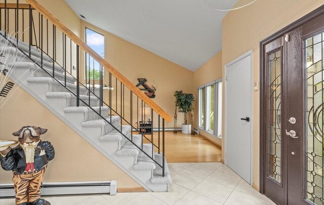 34 Oak Meadow Rd, Commack, NY 11725 - tiled foyer with baseboard heating, stairs, and high vaulted ceiling
