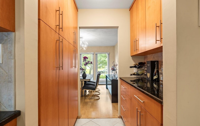34 Oak Meadow Rd, Commack, NY 11725 - kitchen featuring dark stone counters, light tile patterned floors, and brown cabinets