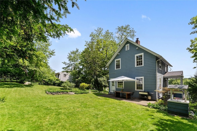 105 James St, Hastings-On-Hudson, NY 10706 - back of house featuring a chimney, a patio, and a lawn