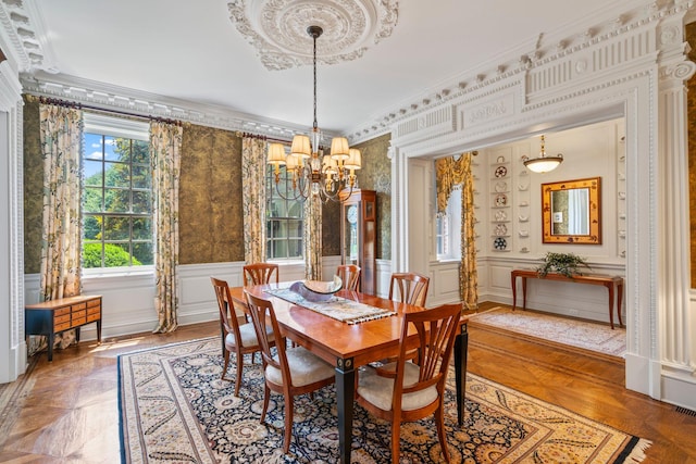 7 Fox Meadow Ln, Lloyd Harbor, NY 11743 - dining room with a chandelier, wallpapered walls, a decorative wall, crown molding, and wainscoting