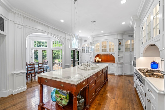 7 Fox Meadow Ln, Lloyd Harbor, NY 11743 - kitchen with stainless steel gas stovetop, crown molding, dark wood-style flooring, white cabinets, and open shelves