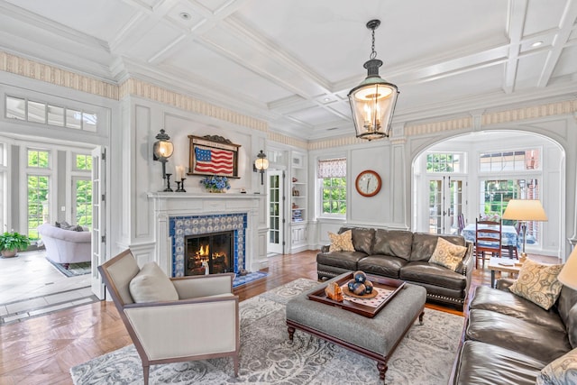 7 Fox Meadow Ln, Lloyd Harbor, NY 11743 - living area with ornamental molding, coffered ceiling, a lit fireplace, a decorative wall, and beamed ceiling
