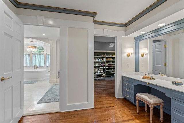 7 Fox Meadow Ln, Lloyd Harbor, NY 11743 - bathroom with a soaking tub, crown molding, vanity, a chandelier, and wood finished floors