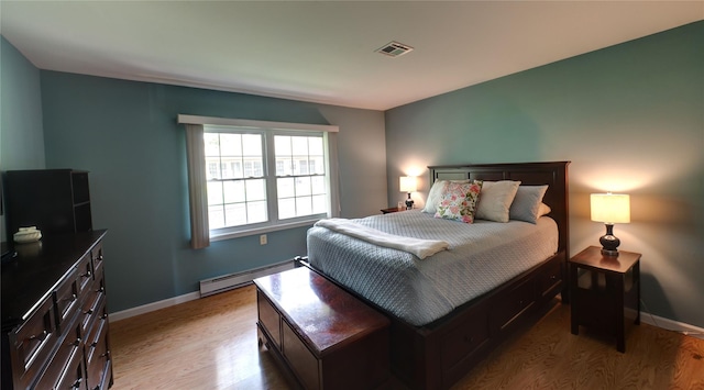 68A Enfield Ct Unit 68A, Ridge, NY 11961 - bedroom featuring a baseboard heating unit, light wood-style flooring, and baseboards