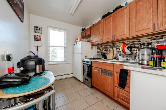 146 First St, Yonkers, NY 10704 - kitchen with gas range oven, baseboard heating, light countertops, decorative backsplash, and a sink