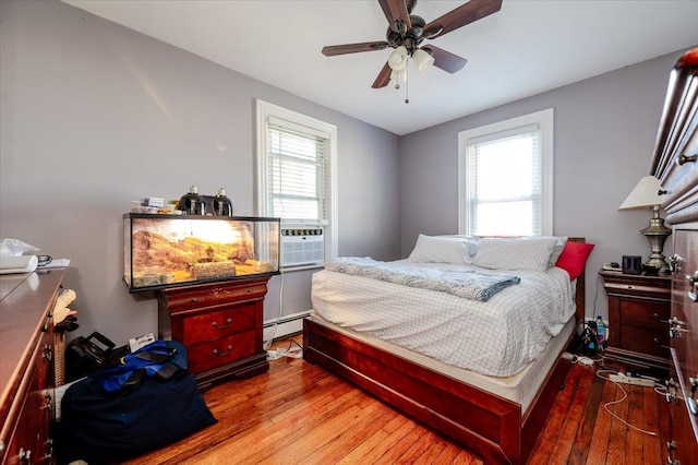 146 First St, Yonkers, NY 10704 - bedroom featuring a baseboard heating unit, hardwood / wood-style floors, cooling unit, and a ceiling fan