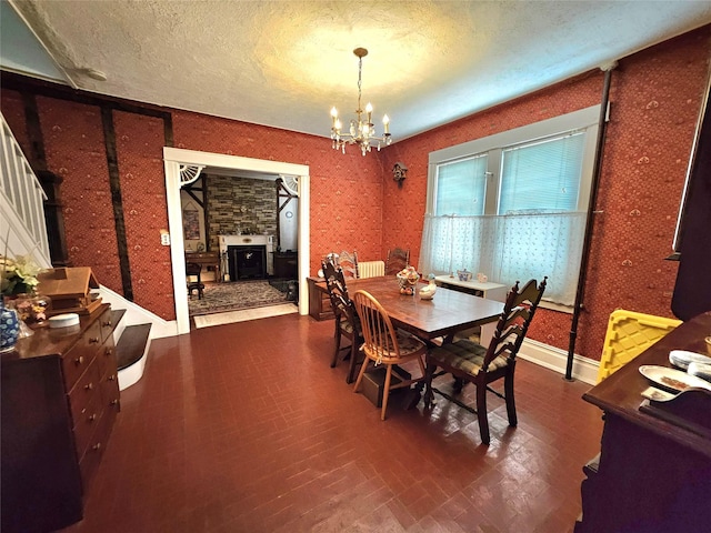 173-12 93rd Ave, Jamaica, NY 11433 - dining area with a chandelier, wallpapered walls, a textured ceiling, a fireplace, and baseboards