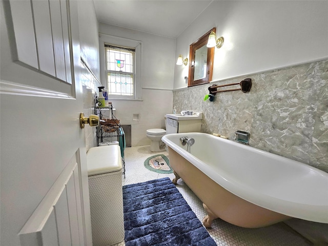 173-12 93rd Ave, Jamaica, NY 11433 - bathroom with a soaking tub, tile patterned floors, a wainscoted wall, toilet, and tile walls