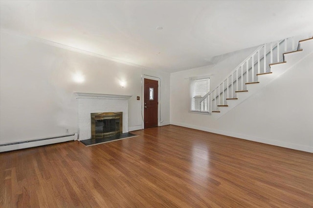 22 N Goodwin Ave, Elmsford, NY 10523 - unfurnished living room with stairs, a baseboard radiator, wood finished floors, a brick fireplace, and ornamental molding