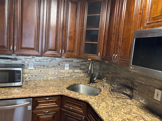 61-55 98th St Unit 14L, Rego Park, NY 11374 - kitchen with appliances with stainless steel finishes, a sink, backsplash, glass insert cabinets, and light stone countertops
