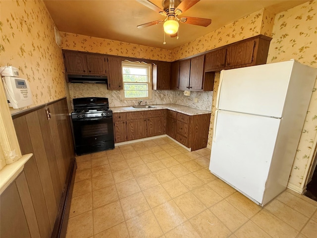 432 49th St, Lindenhurst, NY 11757 - kitchen featuring freestanding refrigerator, gas stove, under cabinet range hood, wallpapered walls, and a sink