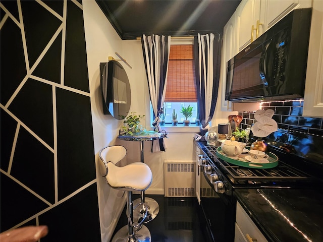 112-25 34th Ave Unit 2D, Corona, NY 11368 - kitchen with black microwave, range, radiator, backsplash, and white cabinetry