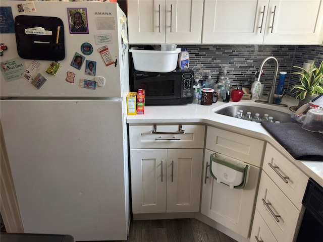 1079 Hunter Ave # 1, Valley Stream, NY 11580 - kitchen with freestanding refrigerator, black microwave, a sink, white cabinetry, and wood finished floors