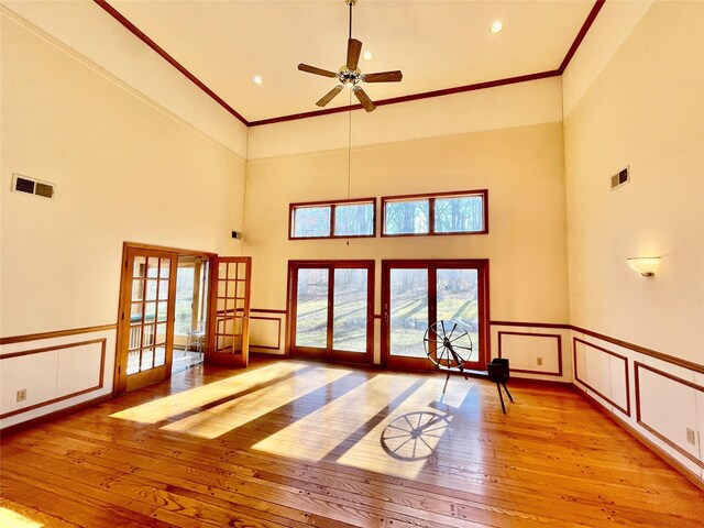 71 Saddleback Ridge Rd, Wallkill, NY 12589 - unfurnished living room featuring french doors, light wood-style floors, a decorative wall, a ceiling fan, and crown molding