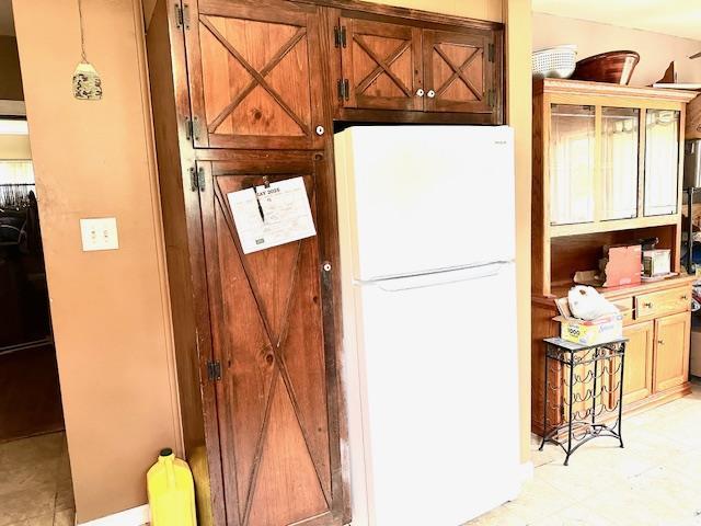 159 Forest Rd E, Mastic Beach, NY 11951 - kitchen with freestanding refrigerator and brown cabinetry