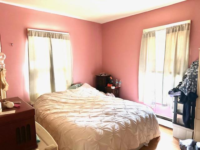 159 Forest Rd E, Mastic Beach, NY 11951 - bedroom featuring baseboard heating and wood finished floors