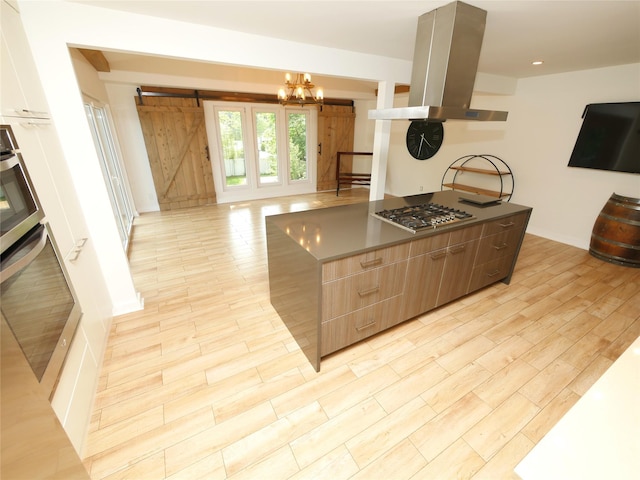 35 Junard Blvd, Port Jefferson Station, NY 11776 - kitchen with stainless steel gas stovetop, island range hood, a barn door, modern cabinets, and oven