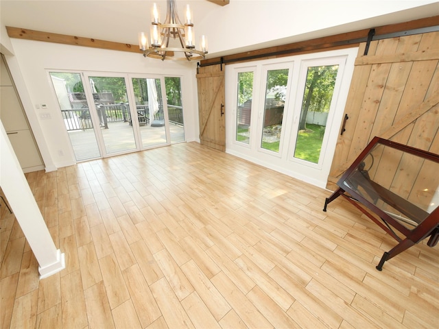 35 Junard Blvd, Port Jefferson Station, NY 11776 - interior space with a barn door, a chandelier, and wood finished floors