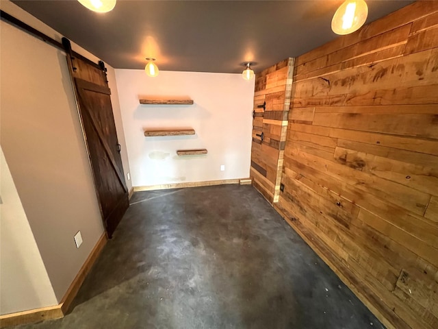 35 Junard Blvd, Port Jefferson Station, NY 11776 - spare room featuring wood walls, a barn door, concrete floors, and baseboards