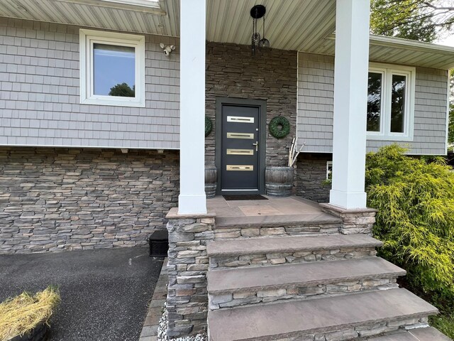 35 Junard Blvd, Port Jefferson Station, NY 11776 - view of exterior entry with stone siding and a porch