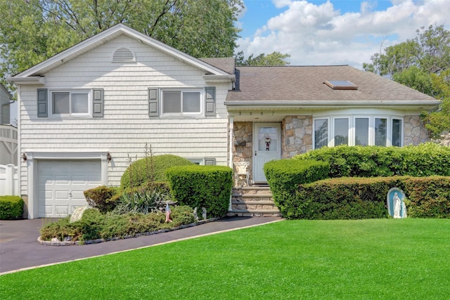 3667 Richard Ln, Wantagh, NY 11793 - tri-level home featuring a front lawn, an attached garage, stone siding, a shingled roof, and driveway