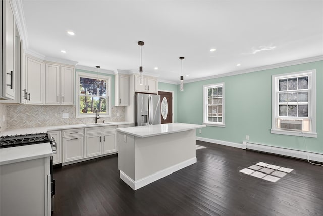104 S Quaker Ln, Hyde Park, NY 12538 - kitchen with stainless steel appliances, baseboard heating, dark wood finished floors, decorative backsplash, and ornamental molding