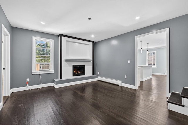 104 S Quaker Ln, Hyde Park, NY 12538 - unfurnished living room featuring a baseboard radiator, healthy amount of natural light, wood finished floors, a lit fireplace, and recessed lighting