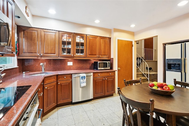 82 Cherry Ln, Lynbrook, NY 11563 - kitchen featuring appliances with stainless steel finishes, brown cabinets, decorative backsplash, glass insert cabinets, and recessed lighting