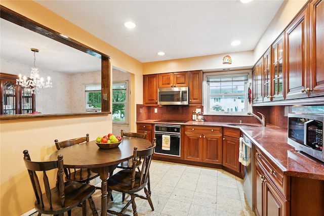 82 Cherry Ln, Lynbrook, NY 11563 - kitchen with stainless steel appliances, recessed lighting, backsplash, plenty of natural light, and brown cabinets