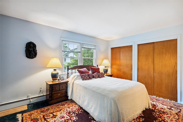 82 Cherry Ln, Lynbrook, NY 11563 - bedroom with a baseboard heating unit and two closets