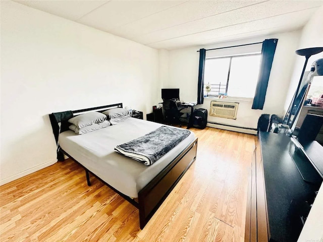 92-29 Queens Blvd, Rego Park, NY 11374 - bedroom with light wood-type flooring, a baseboard radiator, and a wall mounted AC