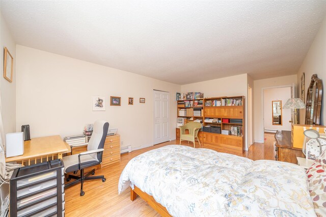 7-05 Briarcliff Dr S, Ossining, NY 10562 - bedroom featuring wood finished floors, an office area, a baseboard radiator, and a textured ceiling