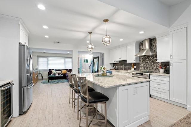 183 Iceland Dr, South Huntington, NY 11746 - kitchen featuring stainless steel appliances, wall chimney exhaust hood, beverage cooler, white cabinets, and light wood-type flooring