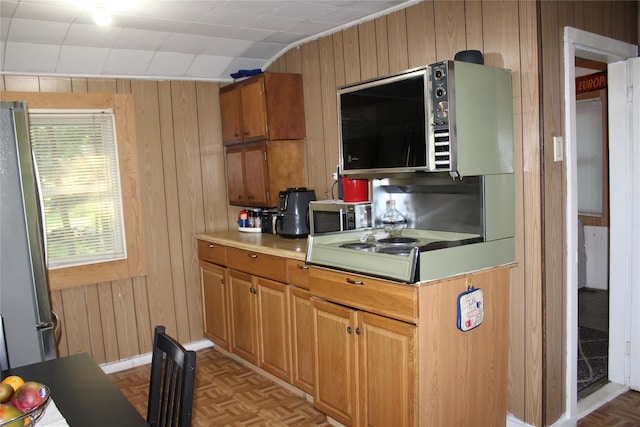 104 Maple Ave, Bethel, NY 12749 - kitchen with wood walls, appliances with stainless steel finishes, light countertops, and brown cabinets