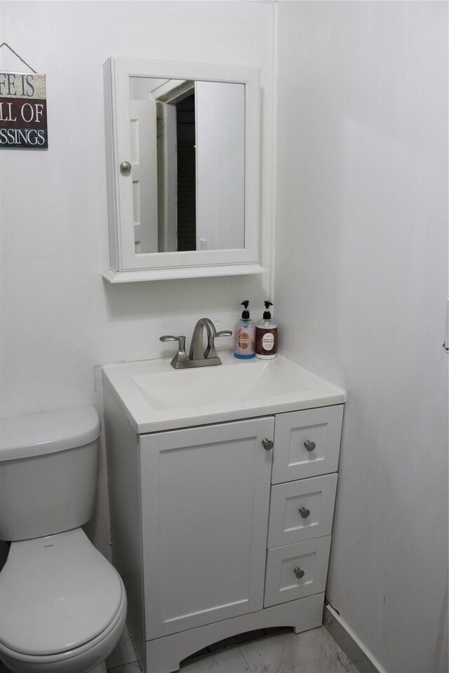 104 Maple Ave, Bethel, NY 12749 - bathroom with vanity, marble look tiles, toilet, and baseboards