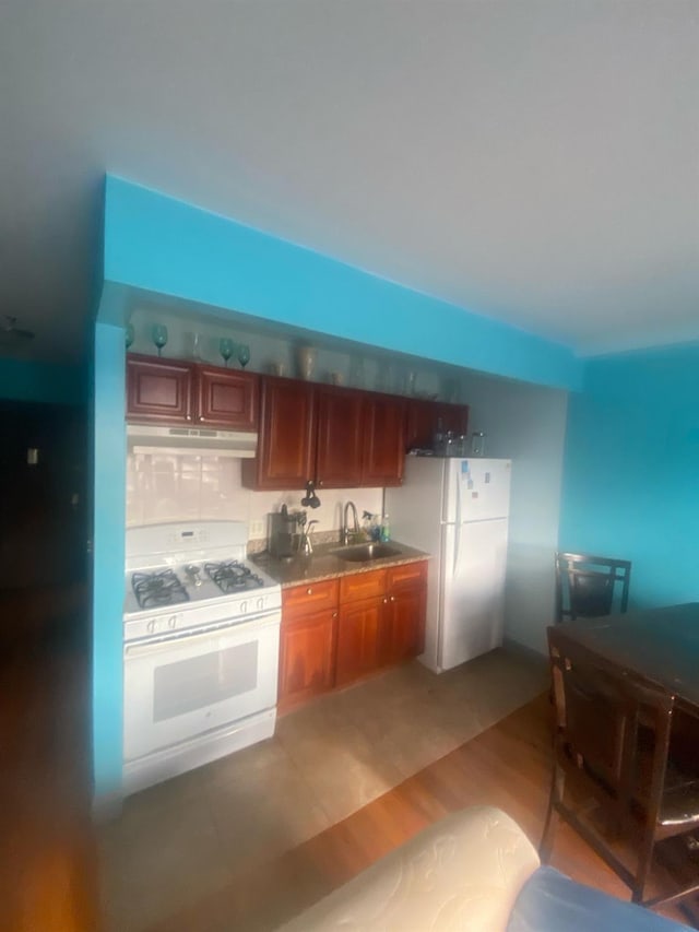 1457 Rosedale Ave, Bronx, NY 10460 - kitchen featuring white appliances, under cabinet range hood, a sink, brown cabinets, and light wood-style flooring