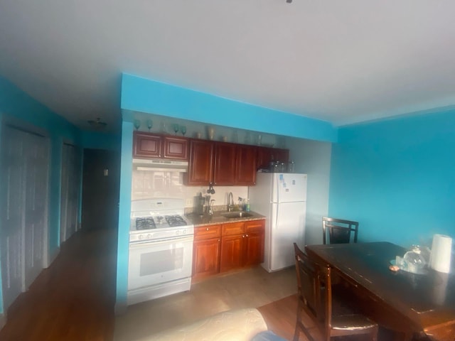 1457 Rosedale Ave, Bronx, NY 10460 - kitchen featuring white appliances, under cabinet range hood, a sink, brown cabinetry, and light wood finished floors