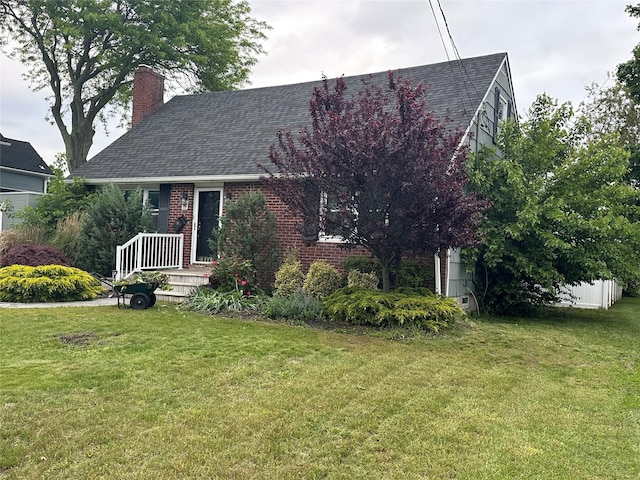 417 S Ocean Ave, Patchogue, NY 11772 - view of front of house featuring a chimney, a front lawn, roof with shingles, and brick siding