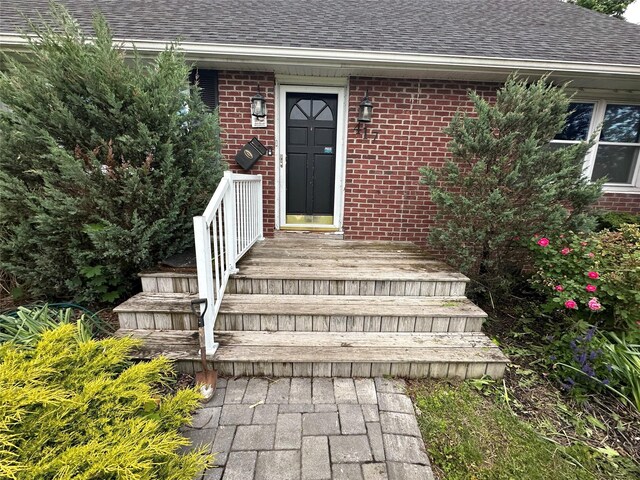 417 S Ocean Ave, Patchogue, NY 11772 - view of exterior entry with a shingled roof and brick siding