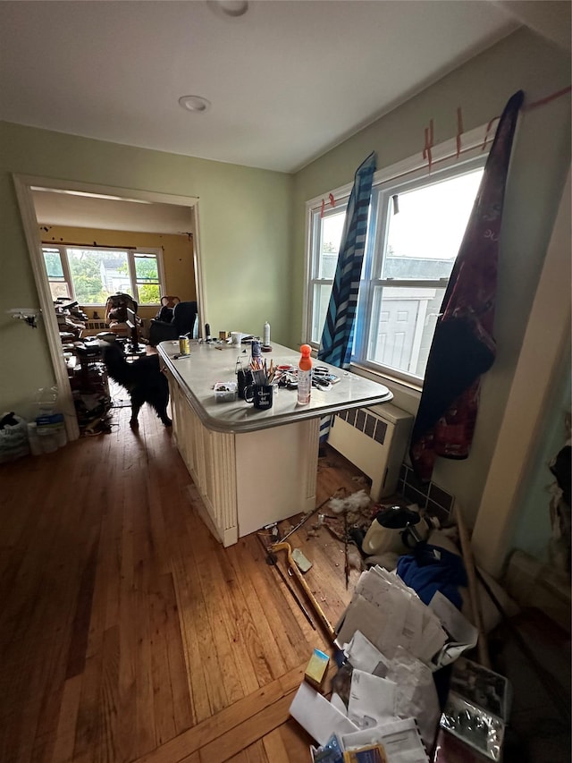 417 S Ocean Ave, Patchogue, NY 11772 - kitchen with radiator heating unit, hardwood / wood-style floors, a kitchen island, and light countertops