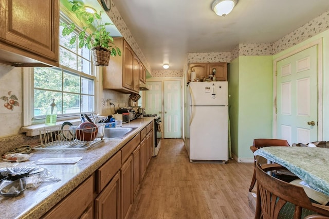 16249 13th Ave, Beechhurst, NY 11357 - kitchen featuring white appliances, light wood-style flooring, brown cabinets, and light countertops