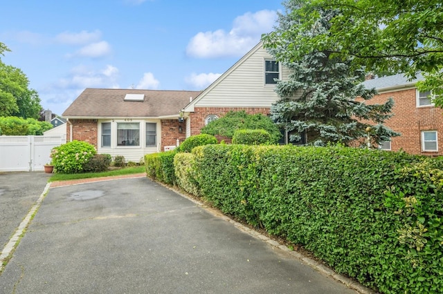 405 Waukena Ave, Oceanside, NY 11572 - view of front of home featuring brick siding, uncovered parking, and roof with shingles