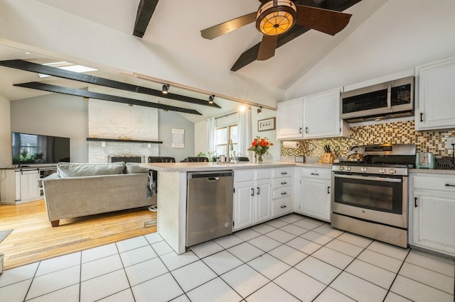 405 Waukena Ave, Oceanside, NY 11572 - kitchen with stainless steel appliances, white cabinets, light tile patterned floors, a peninsula, and light countertops