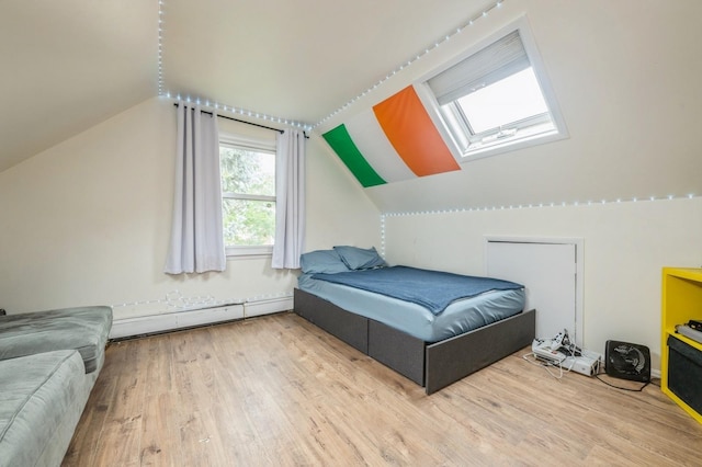 405 Waukena Ave, Oceanside, NY 11572 - bedroom featuring a skylight, baseboard heating, vaulted ceiling, and wood finished floors