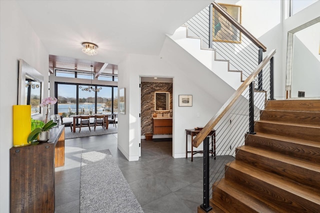 61 Harbor Dr, Sag Harbor, NY 11963 - entrance foyer with stairway, a chandelier, a towering ceiling, and a water view