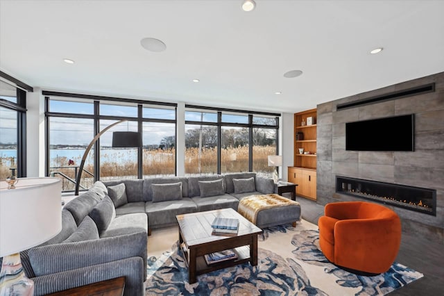 61 Harbor Dr, Sag Harbor, NY 11963 - living area with built in shelves, a tiled fireplace, plenty of natural light, floor to ceiling windows, and recessed lighting