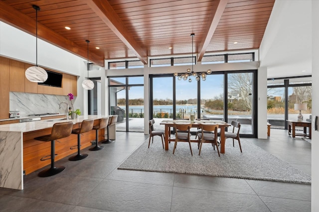 61 Harbor Dr, Sag Harbor, NY 11963 - dining area with a wood ceiling with exposed beams, a chandelier, and floor to ceiling windows