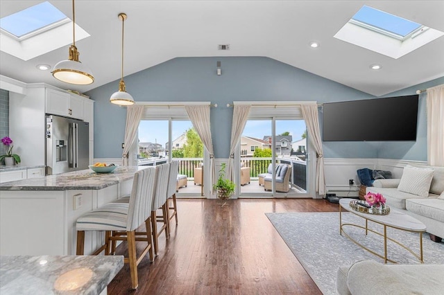 845 Atlantic St, Lindenhurst, NY 11757 - living room with a skylight, a wainscoted wall, vaulted ceiling, dark wood finished floors, and baseboard heating