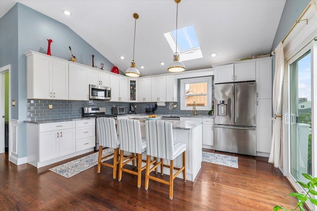845 Atlantic St, Lindenhurst, NY 11757 - kitchen with stainless steel appliances, vaulted ceiling, decorative backsplash, glass insert cabinets, and white cabinetry